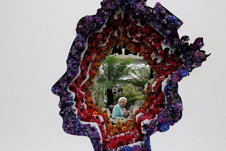 Britain's Queen Elizabeth II is pictured through a floral exhibit in her image at the Chelsea Flower Show. It was made by the New Covent Garden Flower Market in honour of the monarch's 90th birthday.