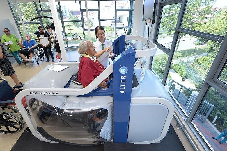 Madam Karumaya Kaiyammal, who is 101 years old, exercising on the anti-gravity treadmill machine under the supervision of physiotherapist Lee Pei Pei at the NTUC Health nursing home in Jurong West yesterday. Based on space technology that uses air pr