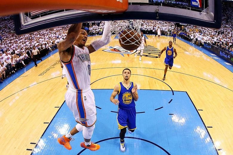 Oklahoma City's Russell Westbrook dunks as Stephen Curry (No. 30) of the Golden State Warriors looks on helplessly on Tuesday. The Thunder's 118-94 victory gave them a 3-1 lead in the Western Conference Finals.