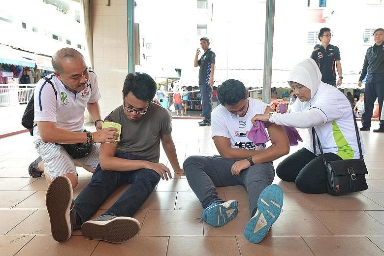 Hostages (far left): The staged scenarios at a media preview this week involved victims held at gunpoint. The injured (left): Participants learnt how common items can help stop bleeding from gunshot wounds. The rescuers (above): The police entering t