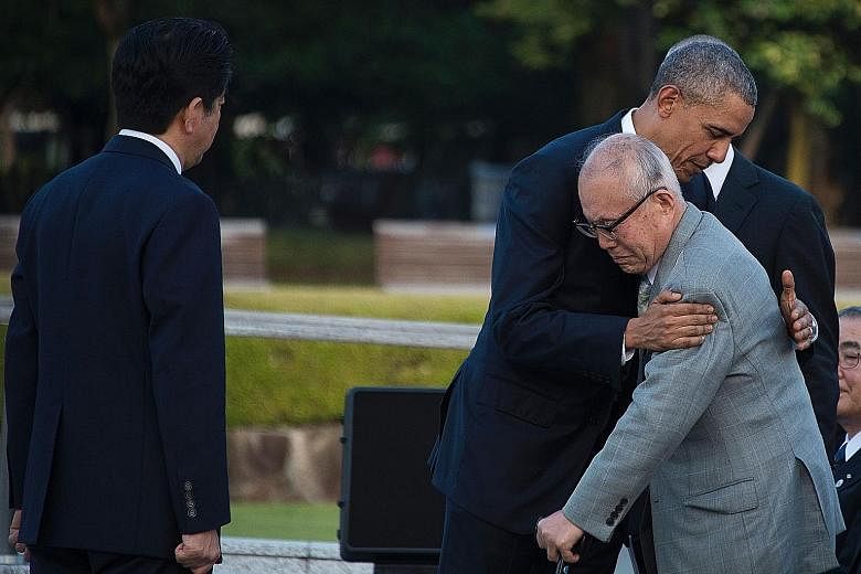 US President Obama hugging a survivor of the 1945 atomic bombing of Hiroshima in an emotional moment during a visit to the Hiroshima Peace Memorial Park yesterday. He is the first sitting American president to make the trip. Mr Obama with Japanese Pr