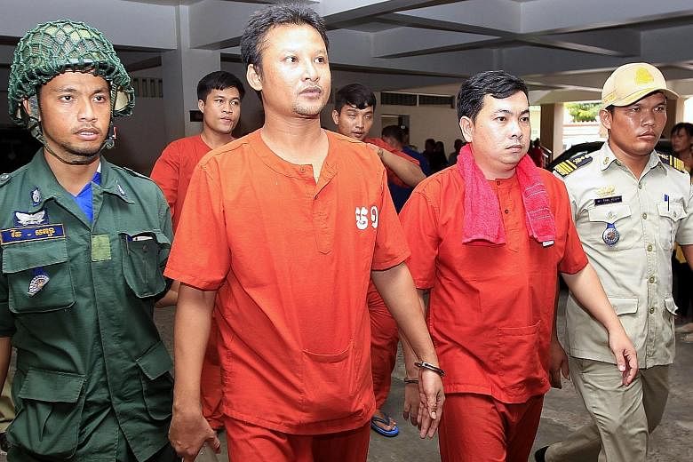 Mao Hoeun (left) and Chay Sarit (right) under police escort at the municipal court in Phnom Penh yesterday. The court has jailed the two men, as well as Sot Vanny, for a year over their attack on two opposition politicians, but the opposition says th