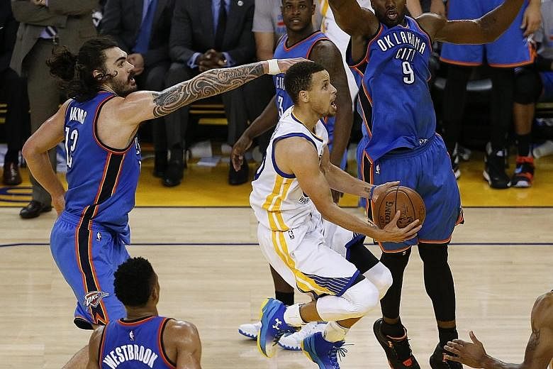 Warriors guard Stephen Curry going to the basket, as Thunder's Kiwi centre Steven Adams (left) and Congolese forward Serge Ibaka defend during Game 5 of the NBA Western Conference finals. Golden State won 120-111 but still trail 2-3 in the best-of-se