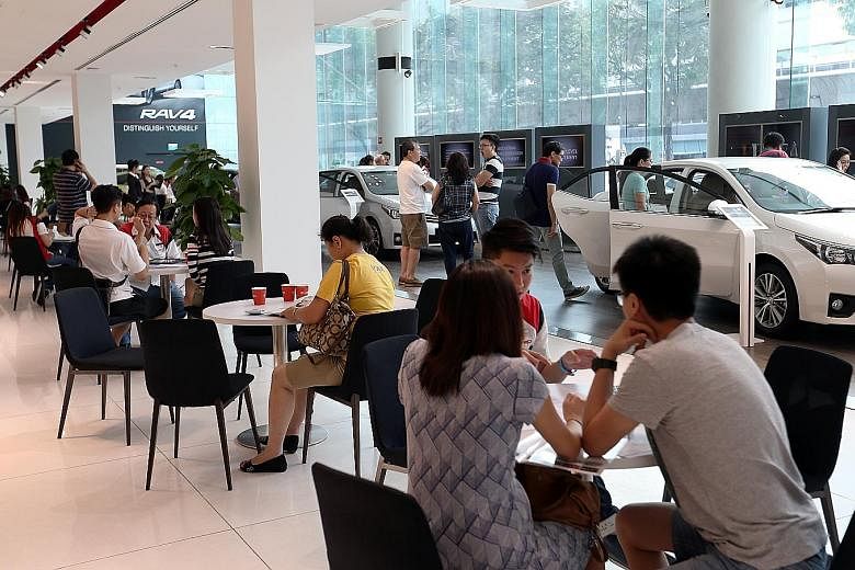 Potential car buyers at the Cycle & Carriage (Mercedes Benz) showroom in Alexandra Road (above) and at Borneo Motors' (Toyota) Leng Kee Showroom (right) yesterday. Both new and used car dealers saw an increase of between 10 and 50 per cent in showroo
