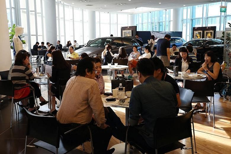 Potential car buyers at the Cycle & Carriage (Mercedes Benz) showroom in Alexandra Road (above) and at Borneo Motors' (Toyota) Leng Kee Showroom (right) yesterday. Both new and used car dealers saw an increase of between 10 and 50 per cent in showroo