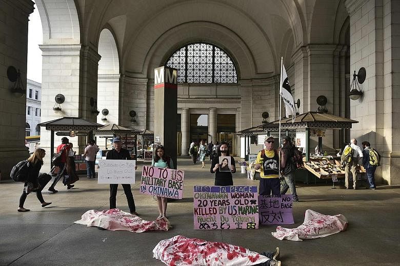 Activists, including some covered in mock shrouds, taking part in a demonstration outside Union Station in Washington, DC, last Thursday to protest against the US military presence in Okinawa and the killing of a 20-year-old Japanese woman.