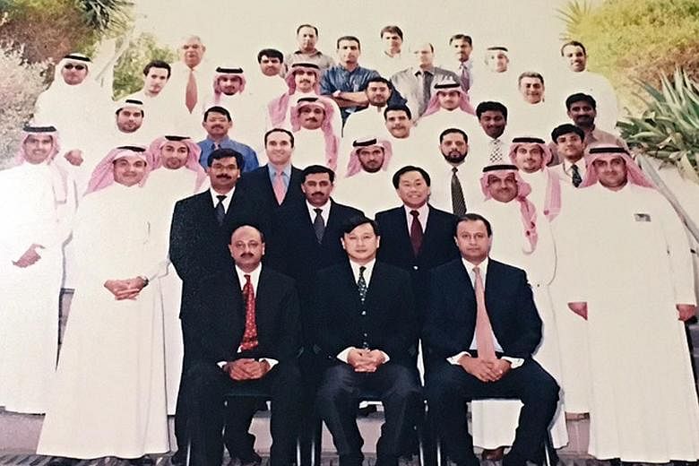 Mr Lim (seated, centre) while heading the Saudi American Bank in Riyadh. There, his family survived a terror attack on their housing complex.