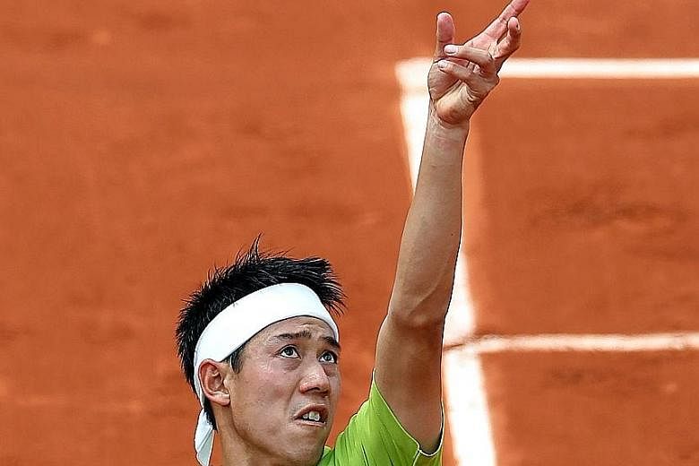 Japan's Kei Nishikori serving during his five-set victory against Spain's Fernando Verdasco in their third-round French Open match on Friday. Nishikori won 6-3, 6-4, 3-6, 2-6, 6-4.