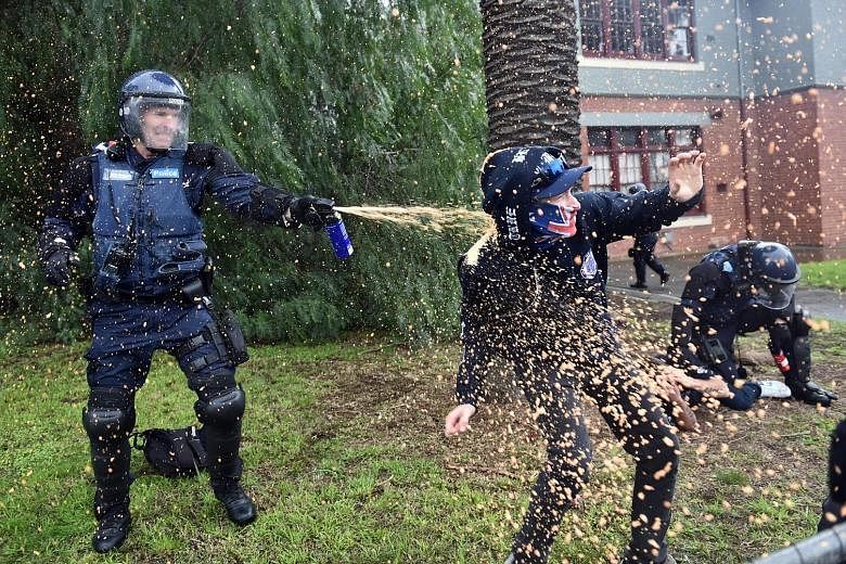 A police officer using pepper spray on a protester in Coburg, Melbourne, yesterday. The United Patriots Front organised a "Stop the Far Left" rally, while anti-racism protesters marched under a banner that said "Moreland says No to Racism". Violence 