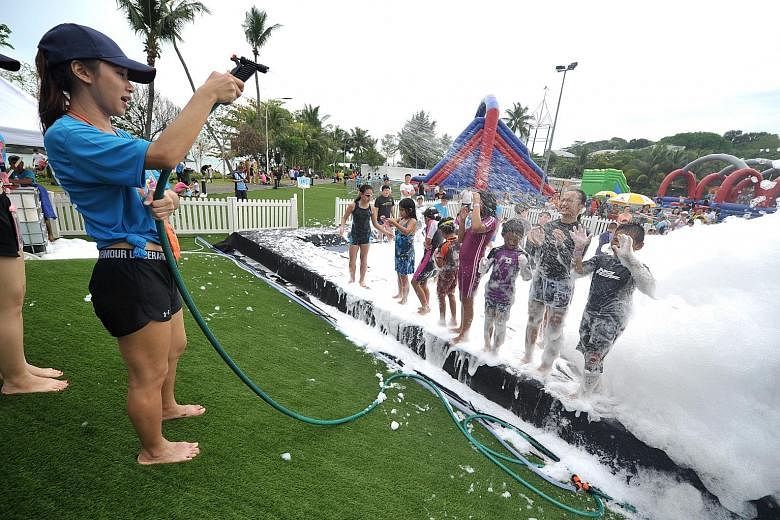 Children at the foam party pit getting sprayed at the NTUC's May Day Fiesta on Sentosa yesterday. Minister in the Prime Minister's Office Chan Chun Sing and NTUC president Mary Liew were among those who joined about 20,000 members at the Sentosa FunF
