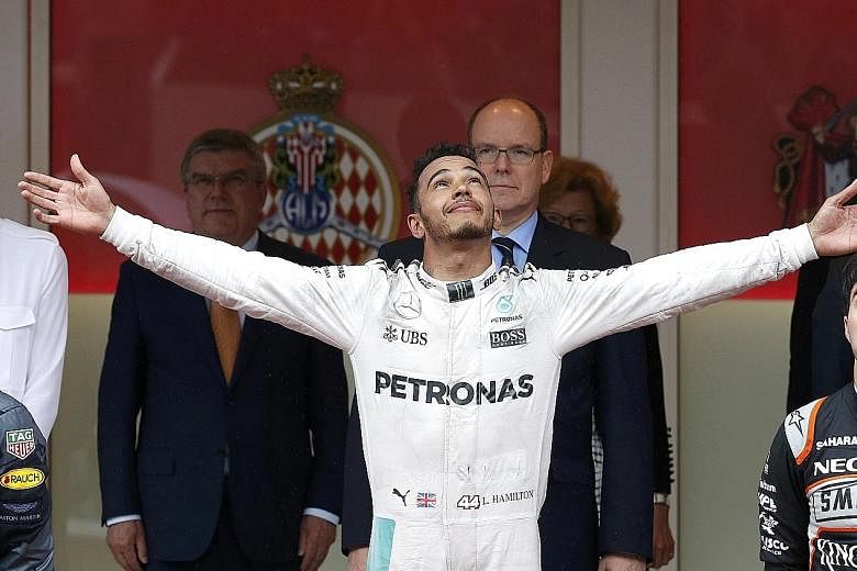 Lewis Hamilton enjoying the crowd's cheers after breaking his eight-race barren run. Prince Albert II of Monaco (behind him) and International Olympic Committee president Thomas Bach (left) look on.
