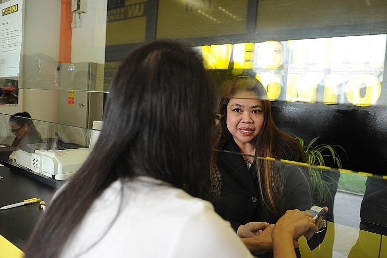 Mrs Ang (right) of Western Union had been trained to spot parcel scams and was able to prevent a customer from falling victim to one.