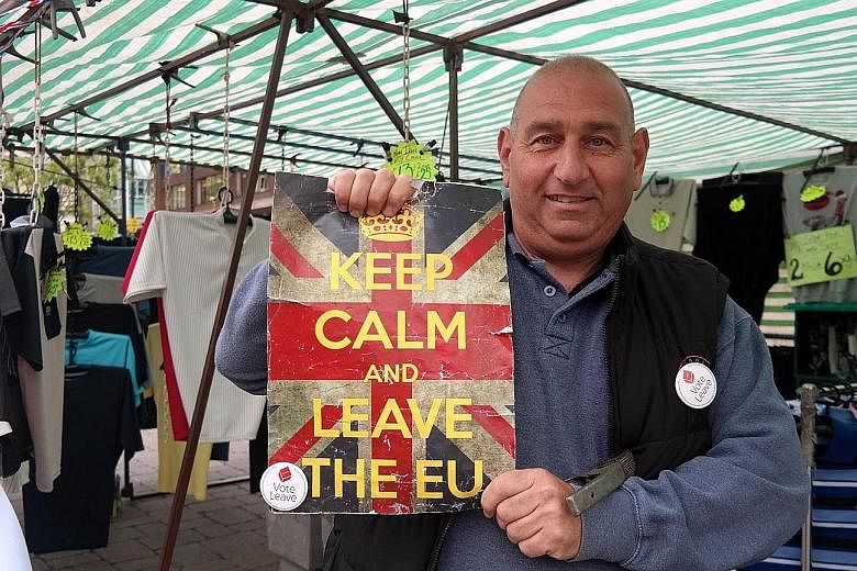 Mr Robert Reuben at his market stall in Romford in the borough of Havering. He says Britain's infrastructure can no longer cope with the inflow of immigrants. Posters encouraging people to register before June 7 to vote in the EU referendum on June 2