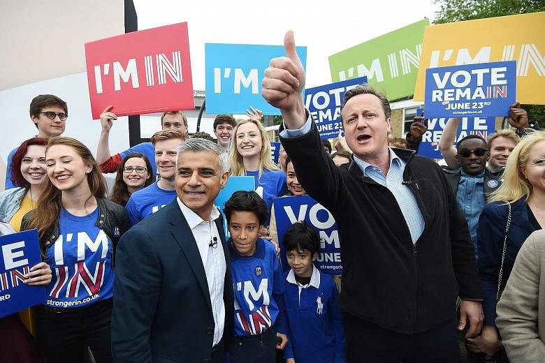 British Prime Minister David Cameron (at right) and London's new mayor Sadiq Khan (far left) campaigning with supporters who want Britain to remain within the European Union.