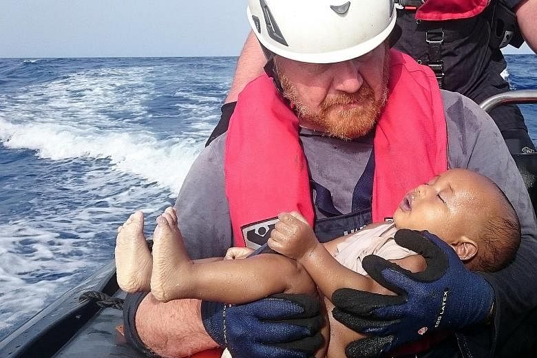The body of a baby in the arms of a rescuer from Sea-Watch, which is a German non-governmental organisation. The body was retrieved from the sea after a wooden boat capsized last Friday off the Libyan coast.