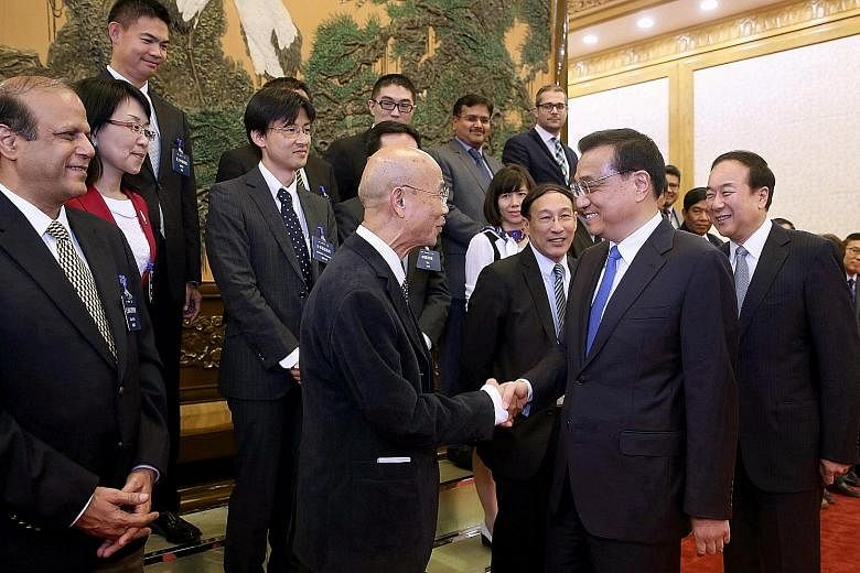 Chinese Premier Li Keqiang shaking hands with Mr Suthichai Yoon, chief adviser of Thailand's Nation Multimedia Group, at the Great Hall of the People in Beijing yesterday. Mr Li discussed a range of issues with editors from the Asia News Network.