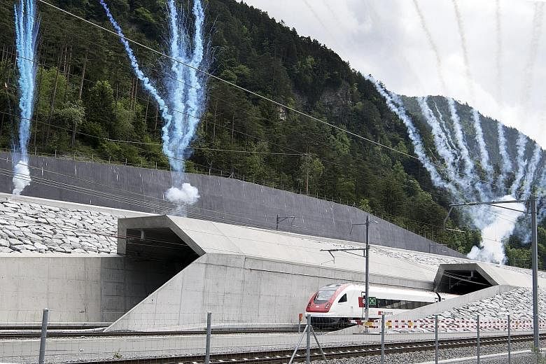 The first train emerging from the North portal of the Gotthard Base Tunnel yesterday. The construction of the Swiss-funded 57km-long tunnel began in 1999, with the breakthrough in 2010. European leaders (from left) Italian PM Matteo Renzi, Swiss Pres