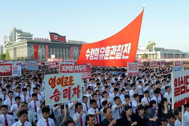 Tens of thousands of North Koreans, brandishing red flags and chanting slogans, parading through Kim Il Sung square in Pyongyang on Wednesday to celebrate the start of the regime's latest five-year economic plan.