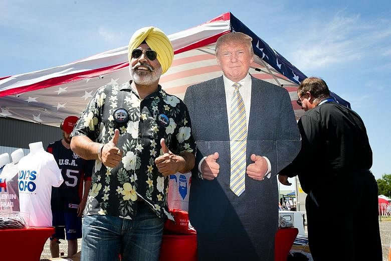 A Trump supporter posing with a cardboard standee of the presidential candidate. The July 18-21 convention is shaping up to be another reminder of the disarray and disunity in the Republican Party.