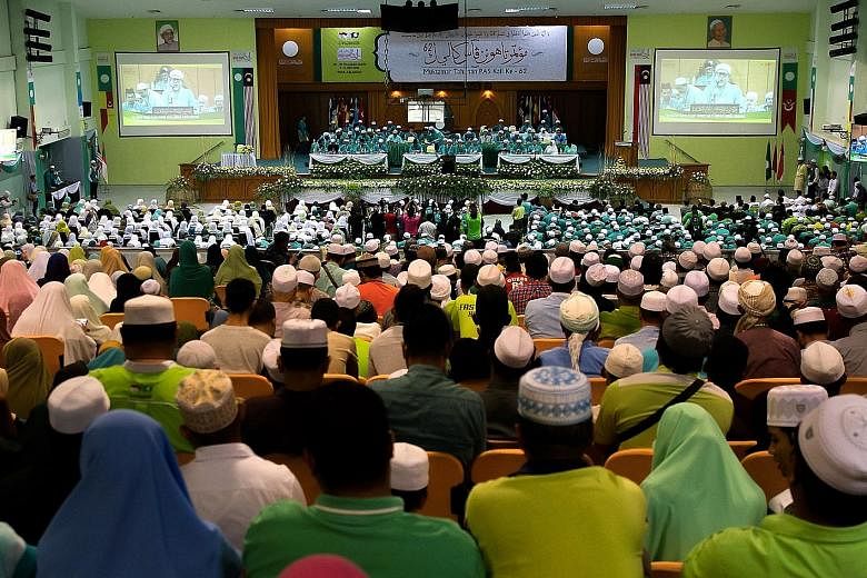 Delegates listening to a keynote address by Parti Islam SeMalaysia president Abdul Hadi Awang at the party's annual congress in Kota Baru yesterday. He says that the party is willing to cooperate with any party that supports its goal of making Malays