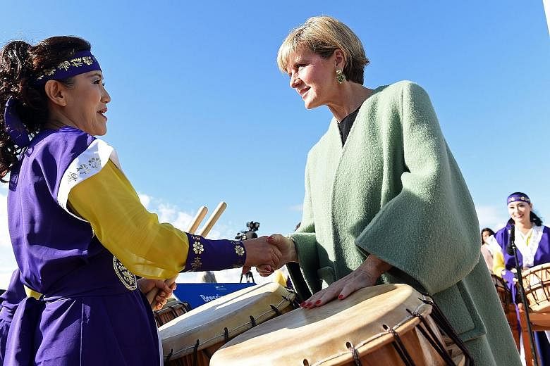 Australian Minister for Foreign Affairs Julie Bishop (right) meeting a member of a Korean drumming troupe at a park in Sydney. The opposition Labor Party's current foreign policy approach on handling China does not sound that much different from hers