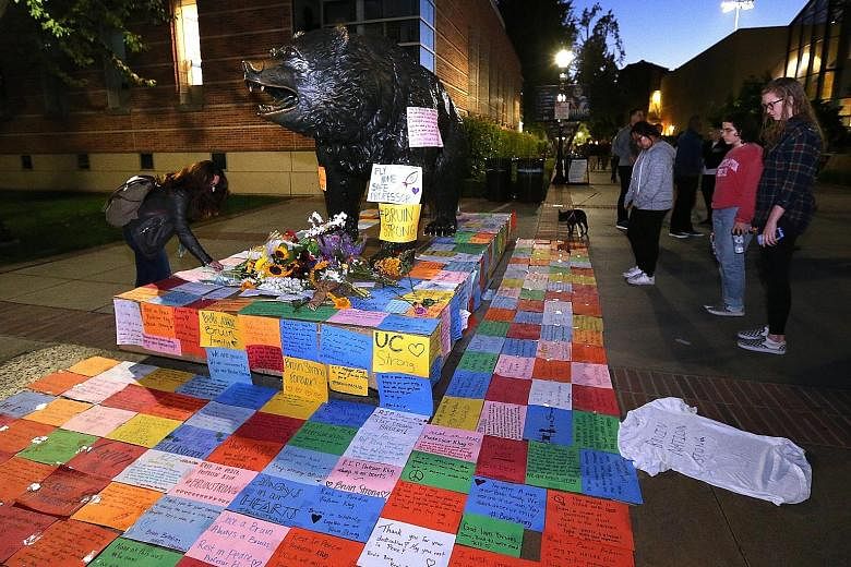 Mementos around UCLA's Bruins statue on Thursday as hundreds paid their respects to Prof Klug in a candlelight vigil. His attacker, Sarkar, shot himself after killing the engineering lecturer.