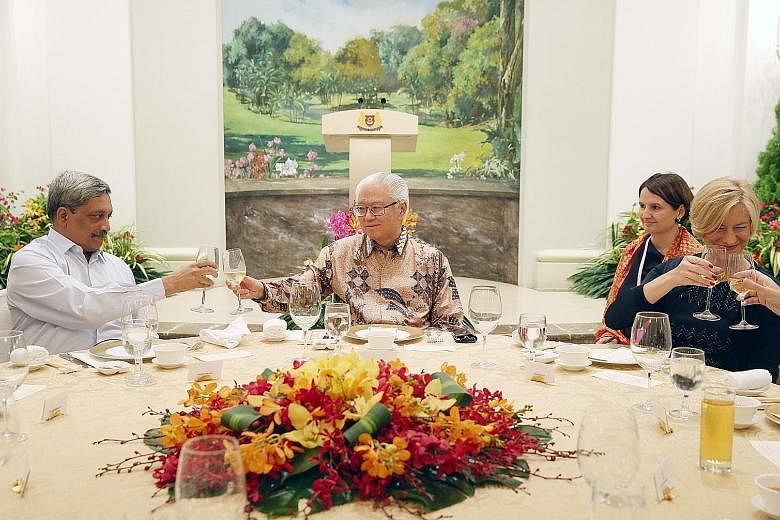 President Tony Tan and Indian Defence Minister Manohar Parrikar exchanging toasts at last night's dinner for delegates of the annual security summit. On the right is Italian Defence Minister Roberta Pinotti.
