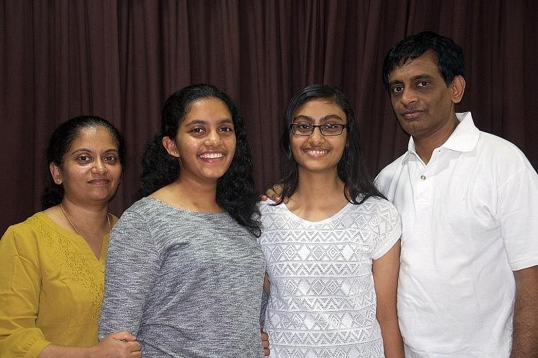 Although Mrs Bindu and her husband Ramesan Panicker are working, they manage without a live-in maid by splitting the housework with their daughters Anjitha (second from left) and Nikhita.