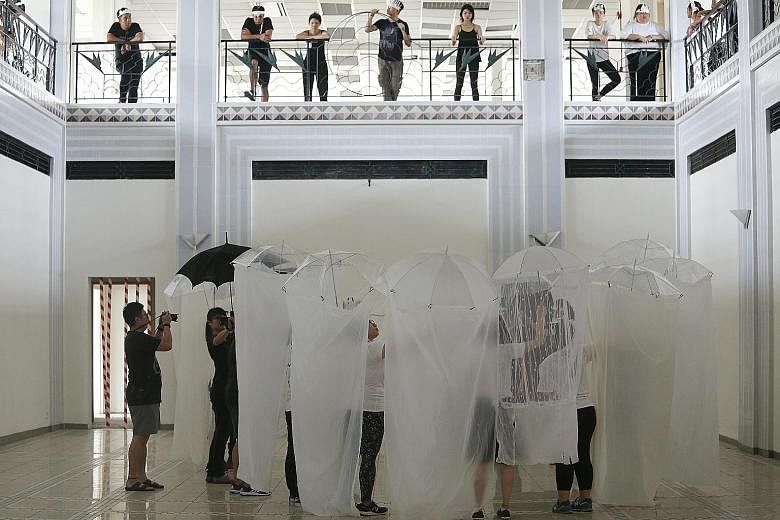 In one of artist Speak Cryptic's show segments, performers carry umbrellas with cloth, forming cocoon-like forms.