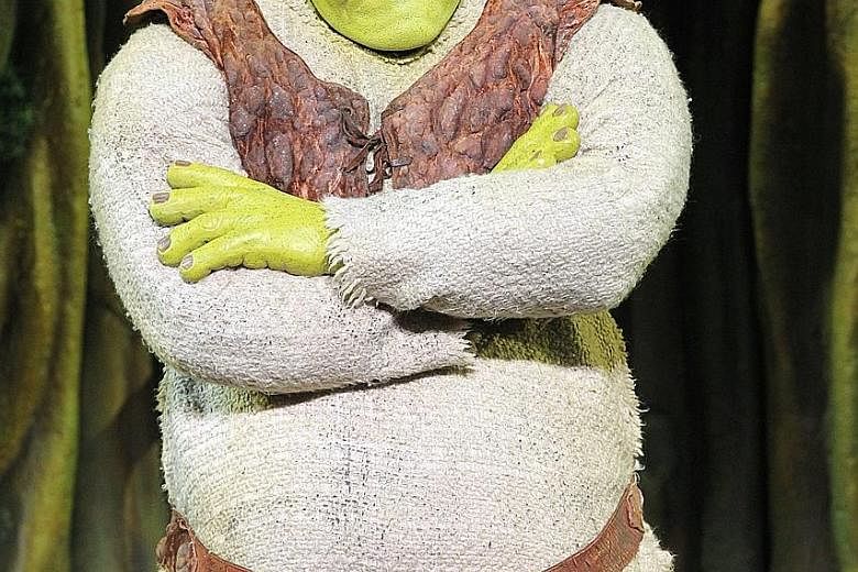 Actor Kyle Timson has to wear a big helmet and don a fat suit to play Shrek (above) in the musical.