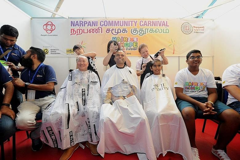 Dr Janil Puthucheary (centre) getting his head shaved for a good cause. Joining him are retiree Teo Jing Teng and student Pranav Srinivasan.