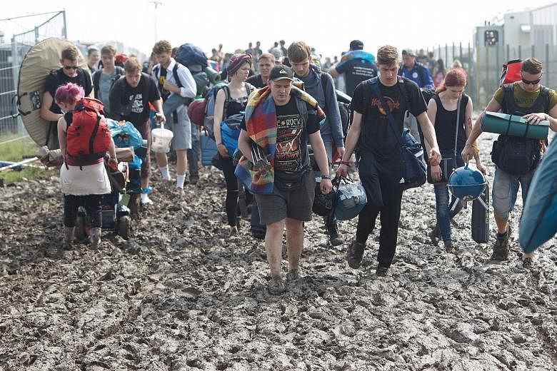 Fans wading through thick mud on the grounds of the Rock am Ring festival in Mendig, Germany, on Saturday. The festival was cancelled after some 80 people were hurt due to lightning strikes.