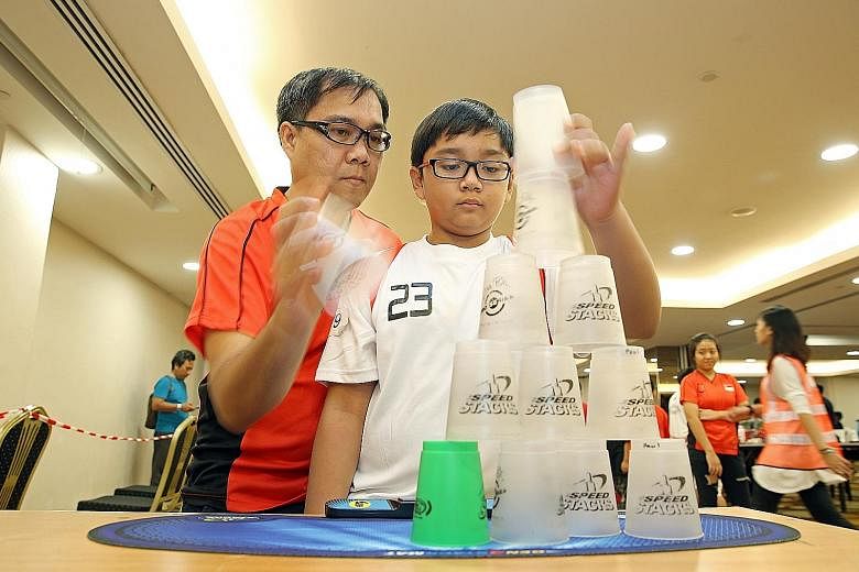 Mr Steve Tubao and his son Paul taking part in the World Sport Stacking Association 2016 Singapore Open held at the Orchid Country Club over the weekend. Mr Tubao also formed a pair with his daughter, Mary. Both pairs won in their "doubles" segments 