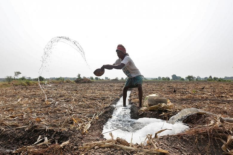 A farmer throwing water after making a canal to irrigate his field in Kolkata, India, last month. Agriculture consumes 83 per cent of India's national freshwater resources as the country strives to feed a huge population, of which more than 15 per cent is