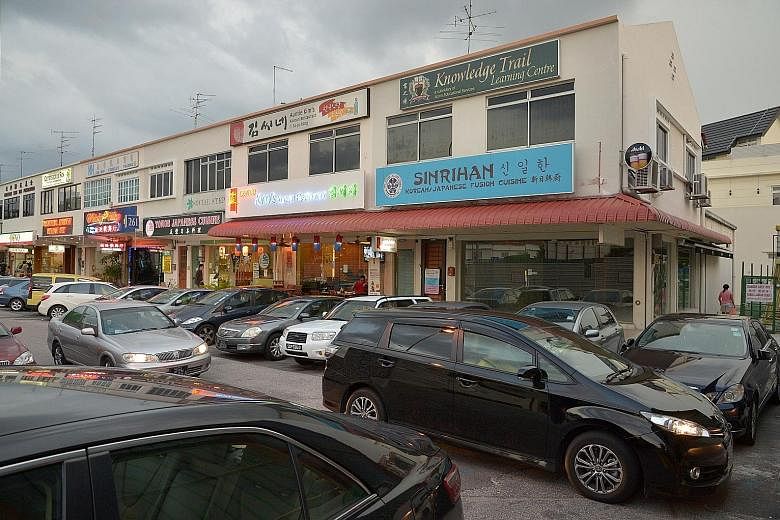 Cars parked in front of a row of shophouses along Upper Thomson Road. The reverse-parked cars blast exhaust fumes into eateries and shops, and into the faces of patrons there, says a letter writer.