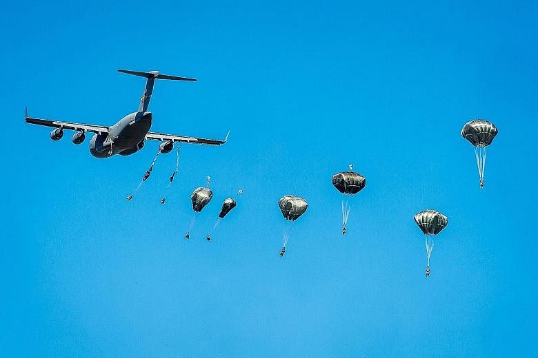 A United States Army C-17 Globemaster military transport plane dropping US paratroopers from the 82 Airborne Division during the Swift Response-16 exercise at a military area near Torun, Poland, on Tuesday. About 2,000 paratroopers from Poland, the U