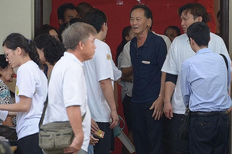 Mr Ong (centre), husband of Madam Seow, attending to mourners at his wife's wake yesterday. A female employee of Mr Ong and Madam Seow described them as good bosses and said Madam Seow "takes care of us very much".