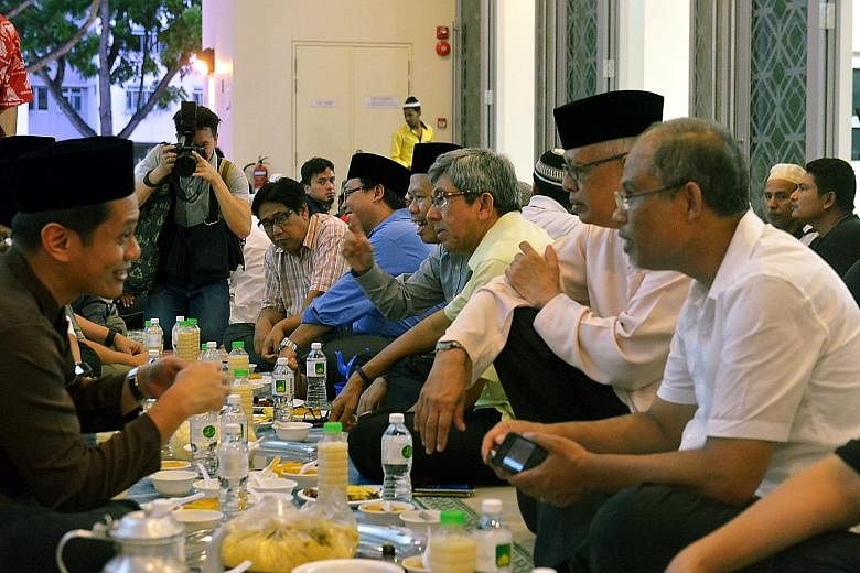 Environment and Water Resources Minister Masagos Zulkifli (right) and Dr Yaacob (third from right) breaking fast with U Care members at Al-Ansar Mosque yesterday.