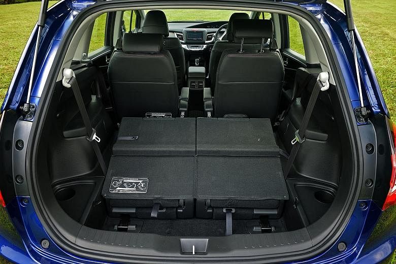 The six-seater Honda Jade (left) has a cosy cabin with premium fit and finish (right) and a third row (above) that can be flipped down to transport bulky items.