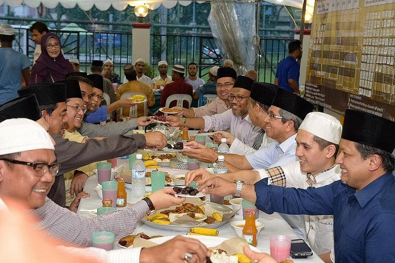 Minister-in-charge of Muslim Affairs Yaacob Ibrahim (third from right) breaking fast with others at the Sallim Mattar Mosque near Aljunied yesterday evening during the holy Muslim month of Ramadan. With a capacity of 1,000, the mosque is popular with