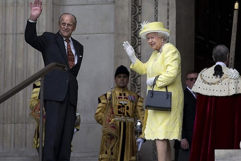 Queen Elizabeth and her husband, Prince Philip, arriving at St Paul's Cathedral in London yesterday to attend a National Service of Thanksgiving to mark the Queen's official 90th birthday. Royal fans with Union Flags and an Australian flag cheering b