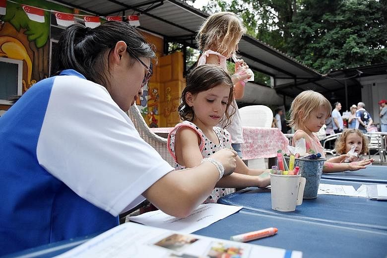 Children getting their arms painted yesterday at the farmers' market in Loewen Road. Melbourne Specialist International School set up a booth there selling cards and bookmarks made by its students to raise funds to build a covered walkway between the