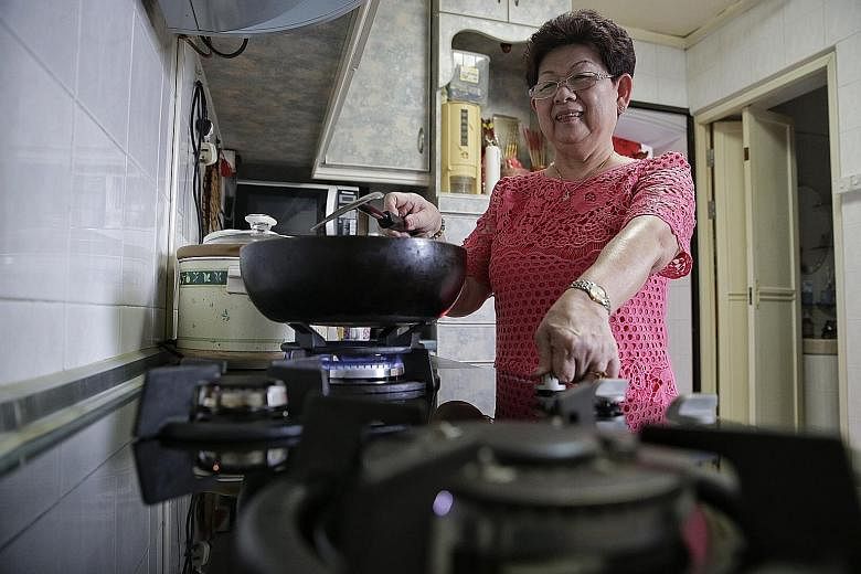 LEFT: Madam Lim, 67, has stopped worrying about being forgetful after getting the new hob last year. ABOVE: The new hob's digital timer can be pre-set to up to 120 minutes. When the time is up, the gas supply is cut off and an alarm alerts the user.
