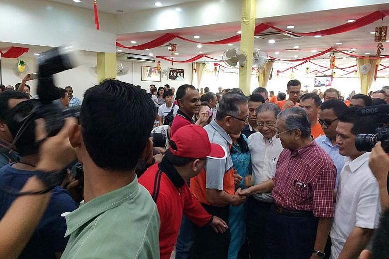Dr Mahathir (right in picture) at a Chinese restaurant in Sekinchan, Selangor, yesterday. Sekinchan is the biggest town in Sungai Besar constituency, one of two where a by-election is being held on June 18.