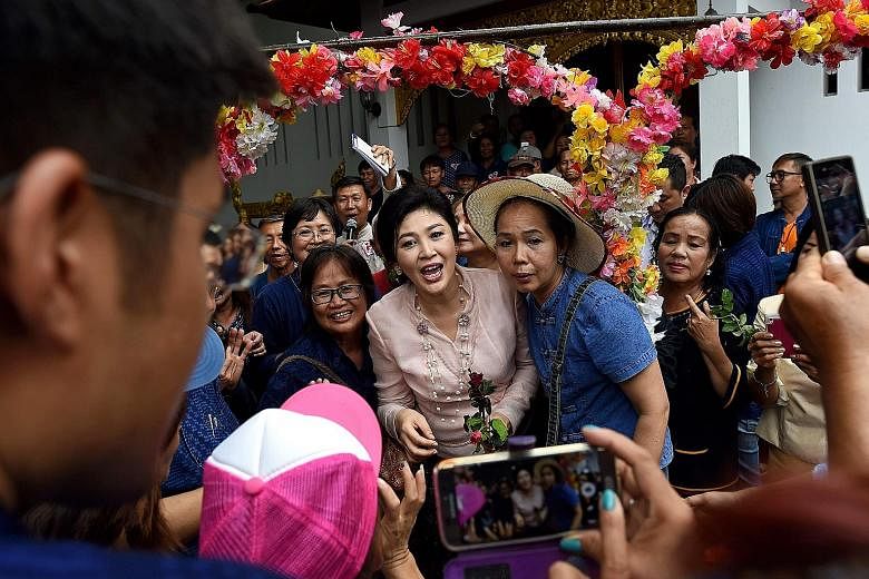 Ms Yingluck posing for pictures with supporters during a visit to a temple in Phrae province, where she was mobbed by photo-taking fans.