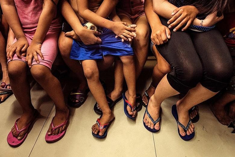 Youngsters detained at a police station in Manila last Wednesday after they were found outdoors past the curfew hour. There are fears that such incidents are traumatising the city's children.