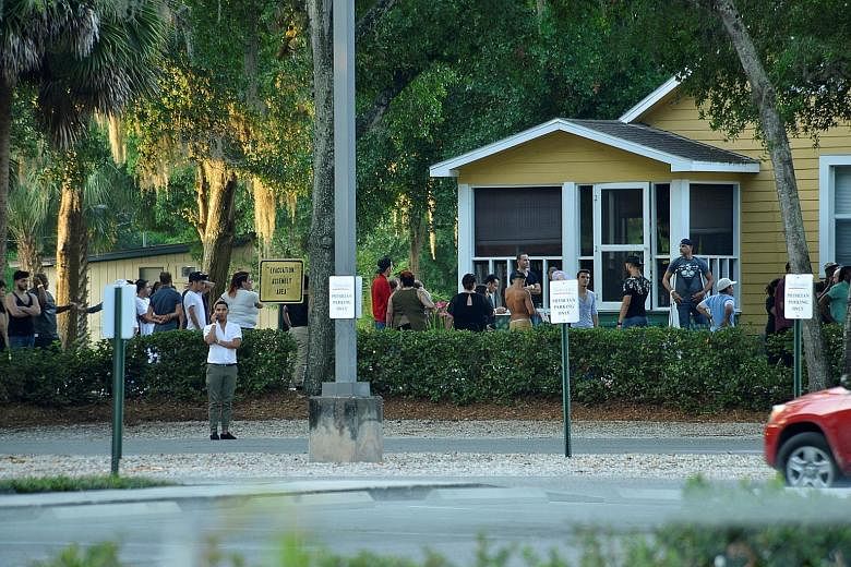 A crowd near the club where police were questioning people. Some had rushed to the club after getting calls from people trapped inside. (Above and left) Friends and family members outside the Orlando Police headquarters yesterday. Officers arriving a