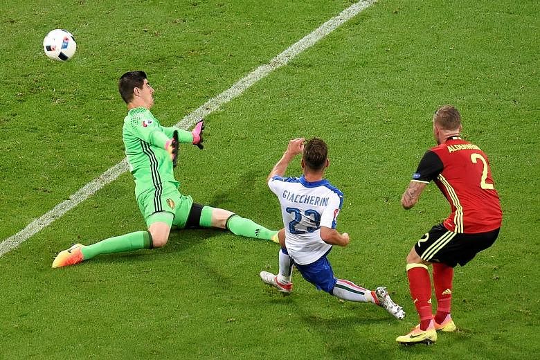 Italy midfielder Emanuele Giaccherini shooting the Azzurri's first goal past Belgium goalkeeper Thibaut Courtois. Belgium were highly rated before the game but flattered to deceive.