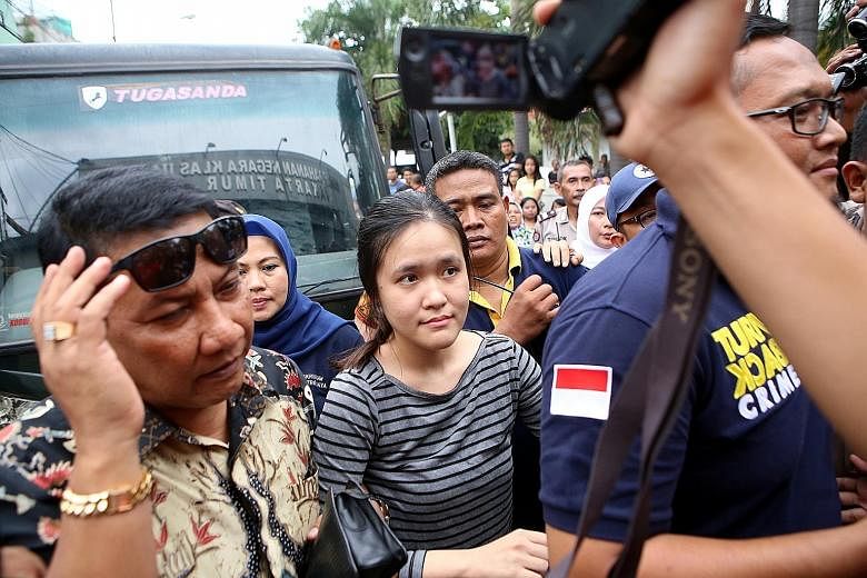 Jessica surrounded by officials as she arrived at the Pondok Bambu Women's Detention Centre in East Jakarta on May 27. The murder suspect allegedly laced her friend's iced coffee with cyanide at a cafe.