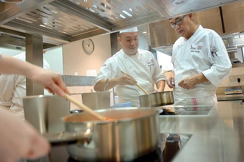 Trainer Lawrence Toon (left), 41, guiding a trainee in the WSQ Certificate in Asian Pastry and Bakery class, where trainees are taught baking techniques, mixing methods and piping skills.